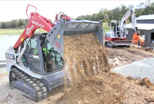 Compact Takeuchi mini excavator with a digging bucket, working on construction site in Australia.